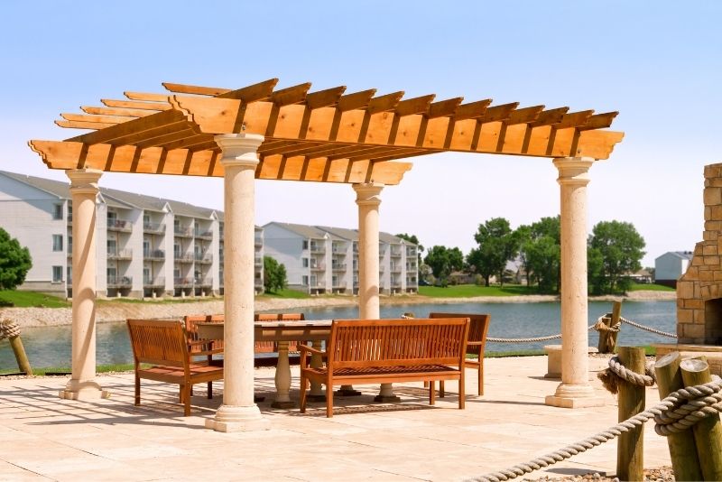 Timber pergola on stone columns overlooking a lake