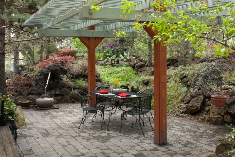 Paved patio with a dining table under a timber pergola