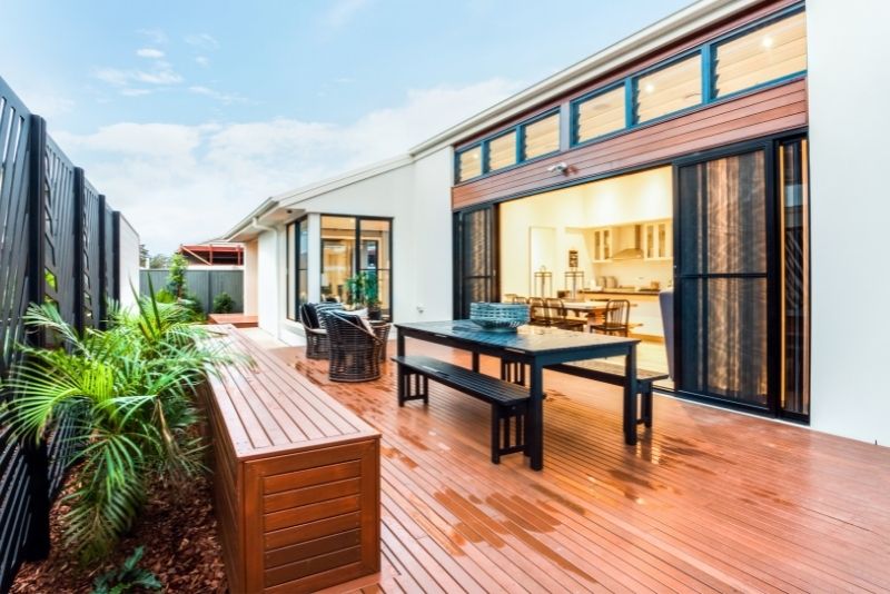 Timber deck with an outdoor dining setting outside open bifold doors
